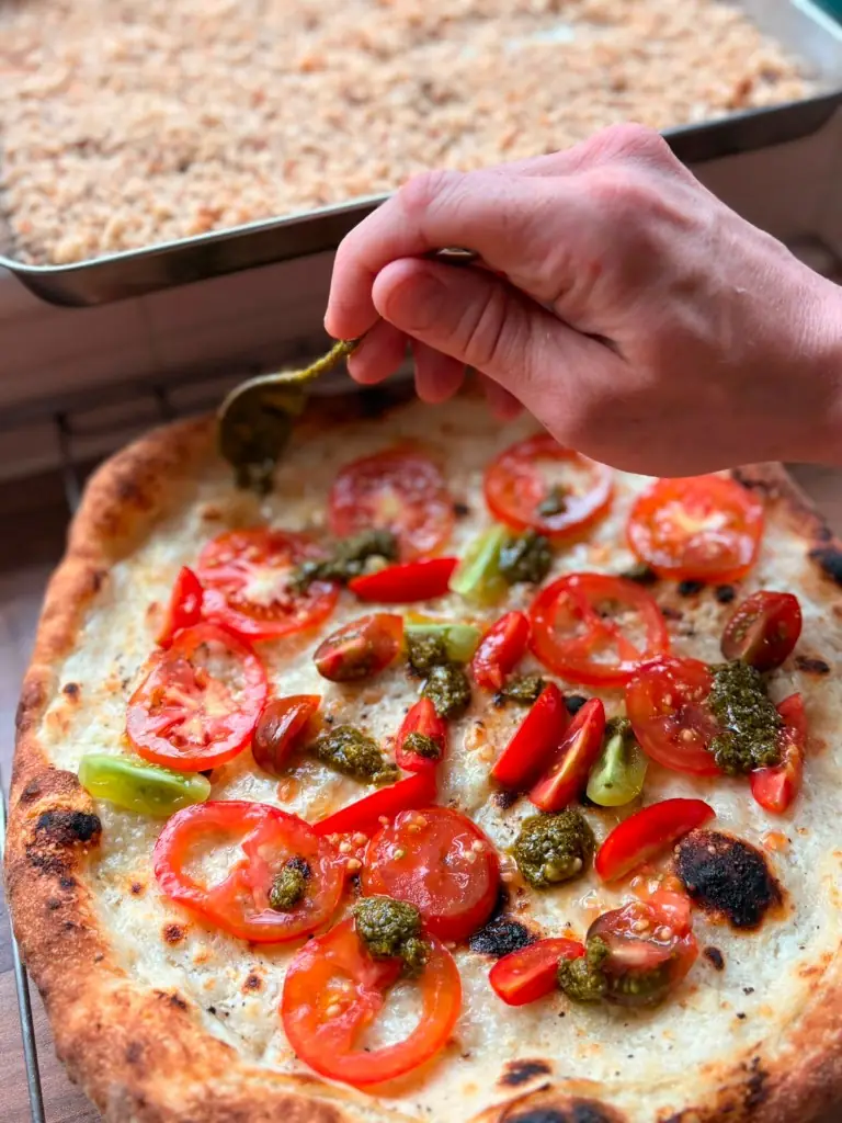 Finishing a pizza with pesto