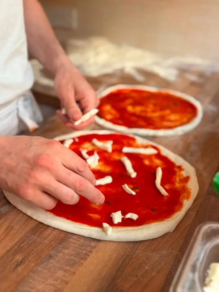 Topping pizza with mozzarella